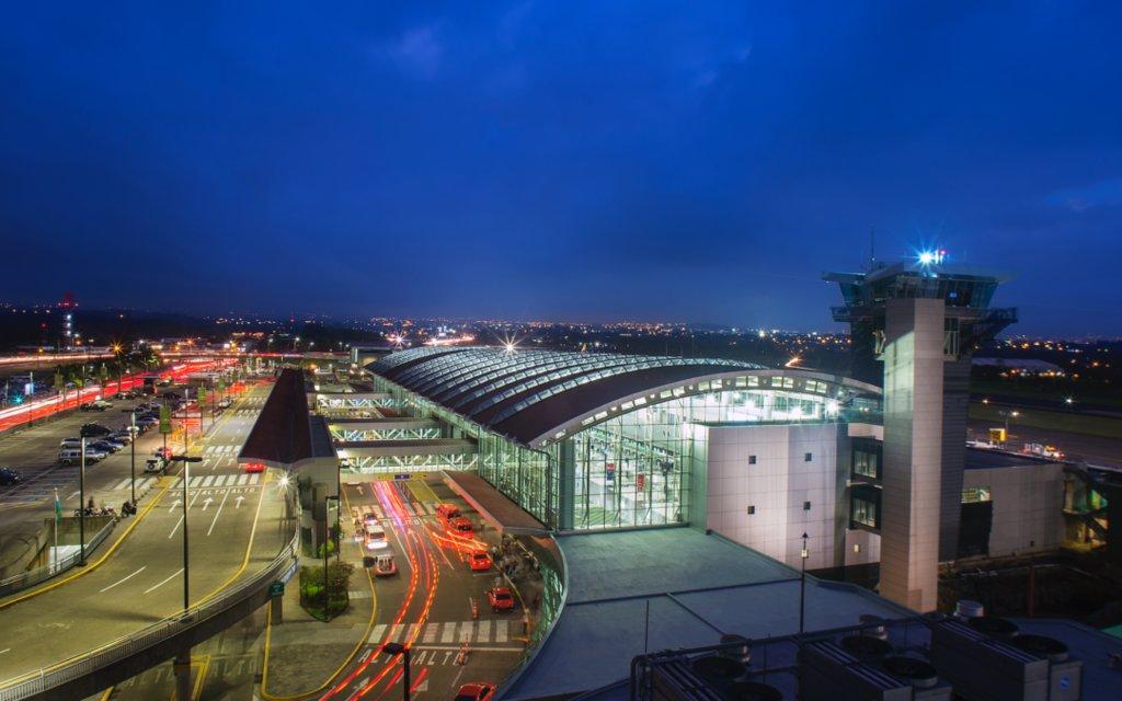 Airport terminal with control tower illuminated at dusk