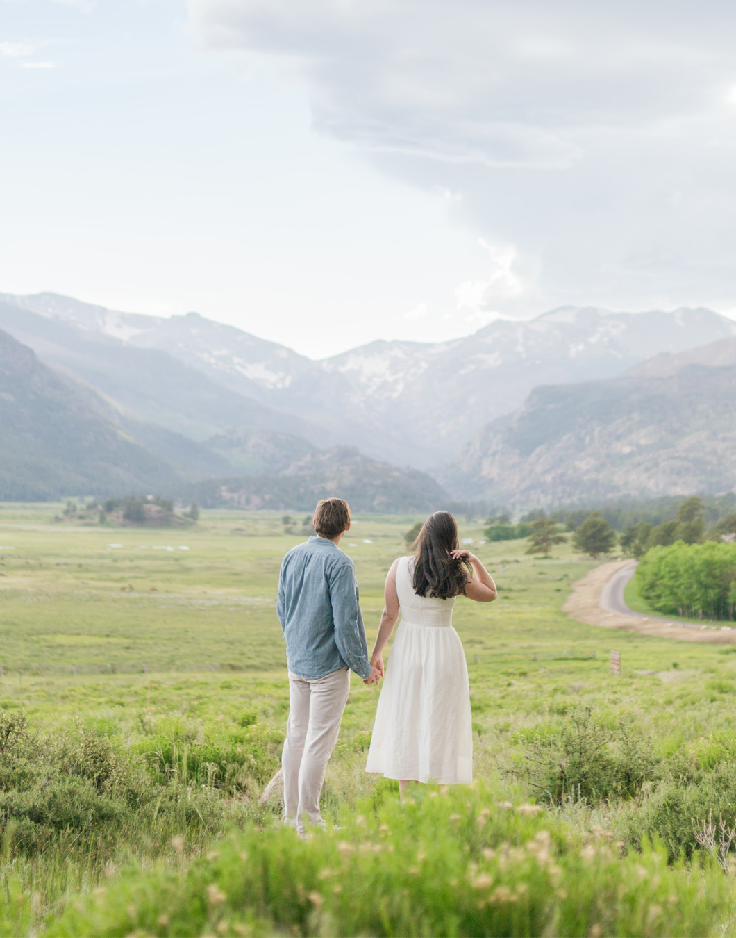 Couple holding hands overlooking the Rocky Mountains