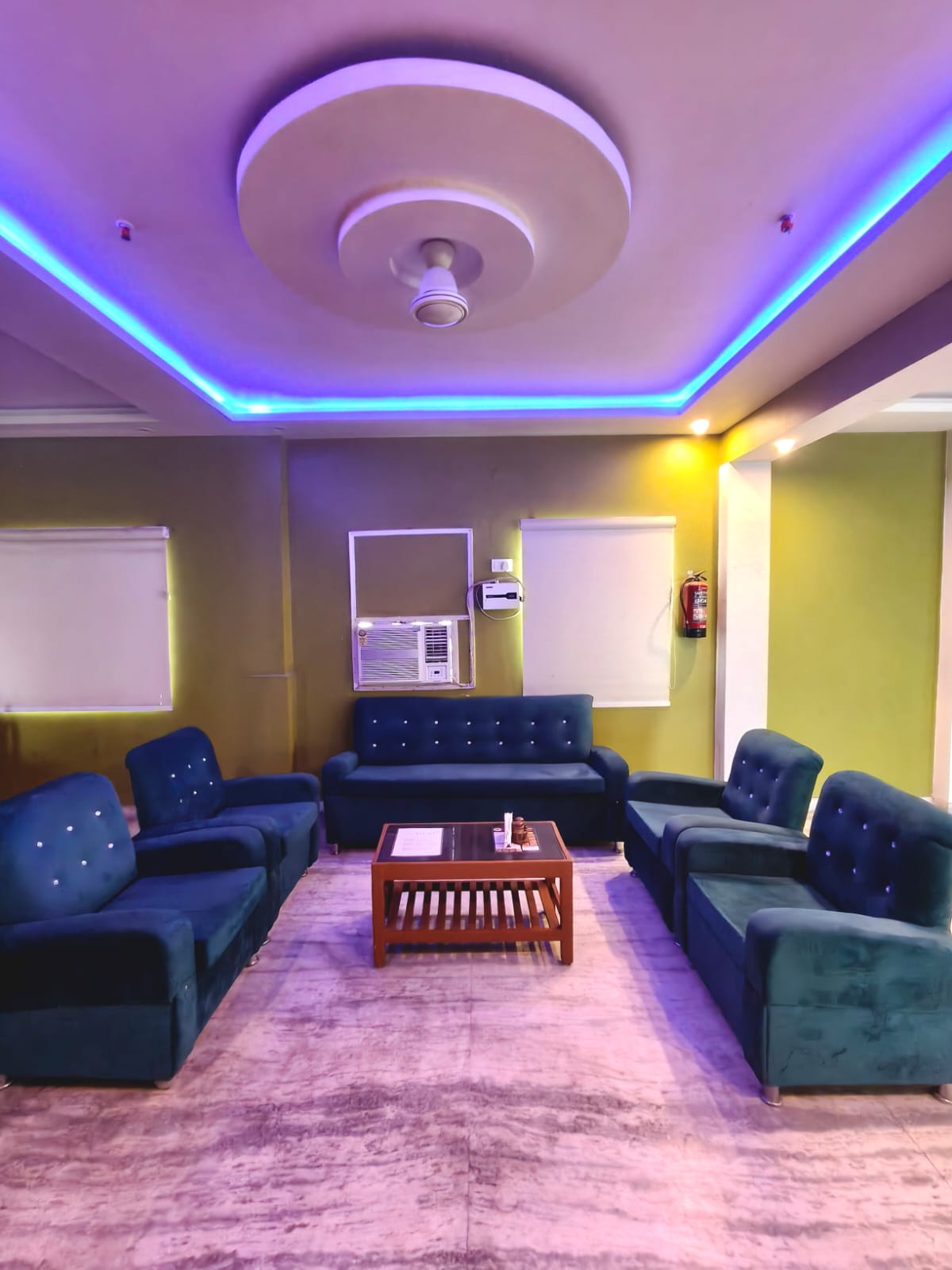 Spacious suite drawing room with teal sofas and LED ceiling, Hotel Virasat Retreat Patna