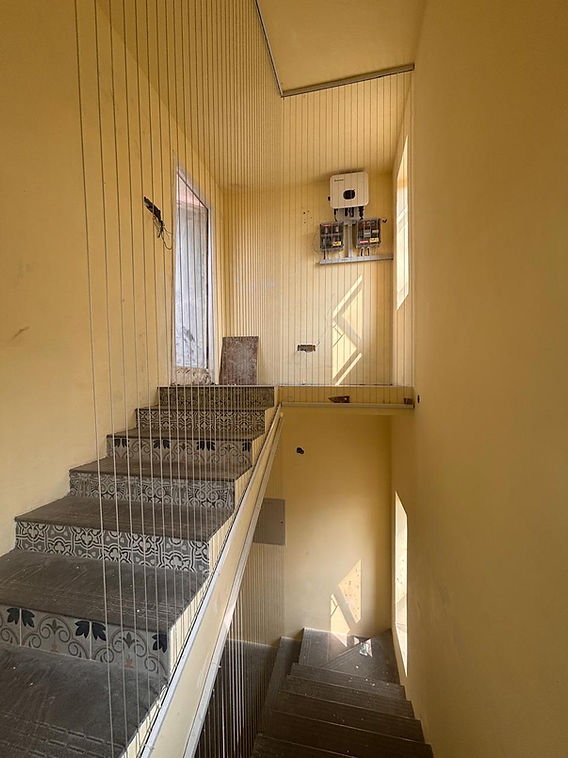 Indoor staircase and landing in a Bengaluru home fitted with closely spaced vertical PR invisible grill safety cables along the open edge
